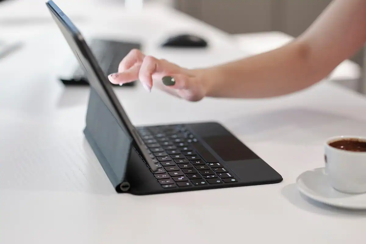 Anunț de angajare tipărit, cu pasaje evidențiate, așezat pe un birou lângă o tabletă și un laptop