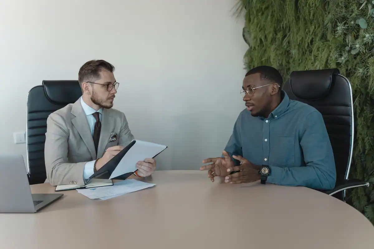 Doi bărbați discută la un interviu de angajare într-un birou contemporan