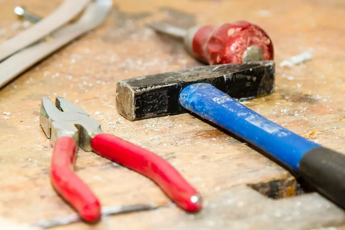Atelier cu clești, șurubelnițe și unelte pe bancul de lucru, imagine despre meseriile calificate