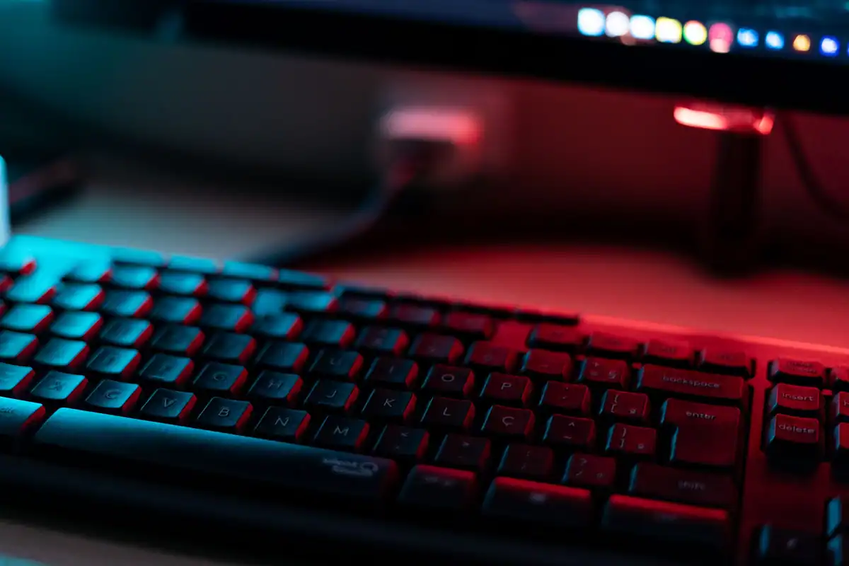 Tastatură de computer luminată în roșu și albastru, văzută de aproape