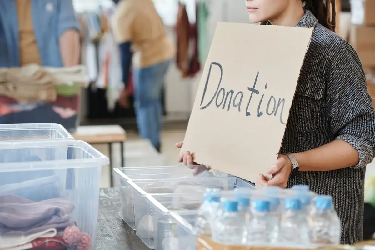 Voluntară care ține un carton de donații la un eveniment caritabil